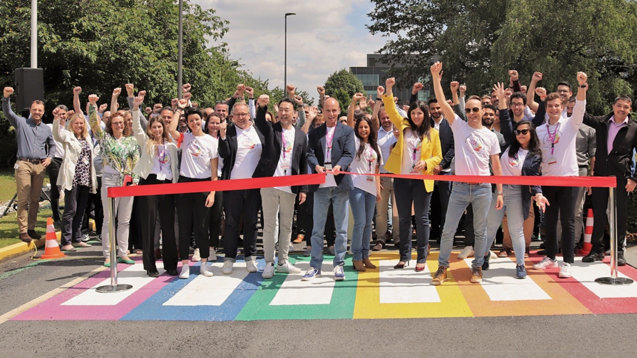 Diverse group of smiling Toyota employees with LGBTIQ+ network t-shirts